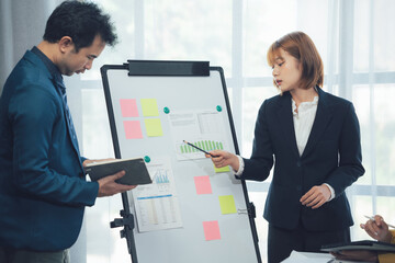 Strategic Collaboration: Business professionals engage in a focused brainstorming session, utilizing a whiteboard and sticky notes to map out their strategic plan.