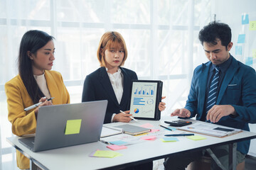 Business Professionals Analyzing Data: A team of diverse business professionals collaborates and analyzes data on a tablet. They are focused and engaged.