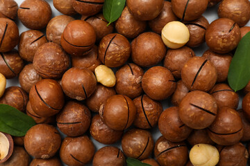 Texture of tasty macadamia nuts on grey background, closeup