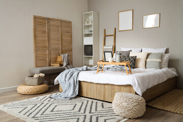 Interior of bedroom with ladder, folding screen and soft bench
