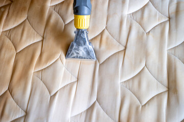 Mattress cleaning machine and cleaning detail shot. Yellowed mattress washing by professional...