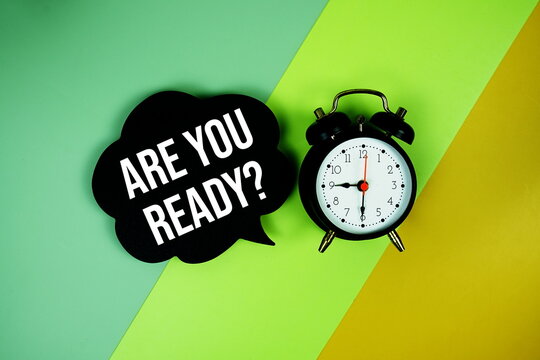 Are You Ready? text on speech bubble with alarm clock top view on green and yellow geometric background