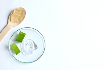 Cut aloe vera and cosmetic gel smears on white background, flat lay. Place for text