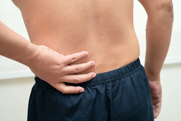 Naklejka premium Asian man pain back muscle, spine and bone from accident.