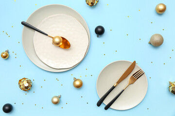 Beautiful table setting with Christmas balls on blue background