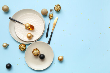 Beautiful table setting with Christmas balls on blue background