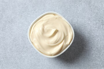 Bowl with mayonnaise on gray background