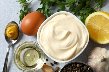Bowl with mayonnaise and ingredients for cooking on wooden background