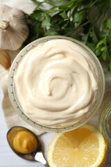 Bowl with mayonnaise and ingredients for cooking on wooden background