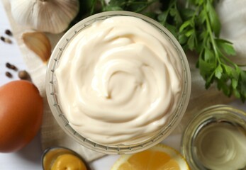 Bowl with mayonnaise and ingredients for cooking on wooden background