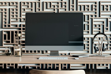 Modern designer workplace with decorative ornamental wall, various small items and big computer monitor with mock up place. 3D Rendering.