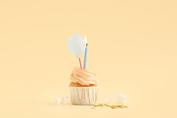 Sweet Birthday cupcake with burning candle and confetti on yellow background