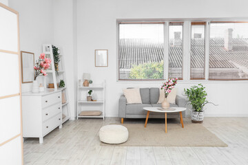Interior of living room with magnolia flowers on coffee table
