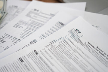 Request for Taxpayer Identification Number and Certification form placed on set of tax forms necessary for taxpayers to ensure accurate reporting of income