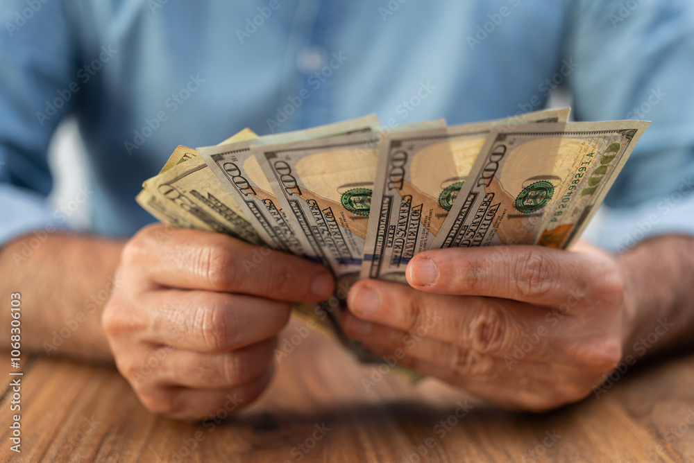 Poster man company accountant holds dollar banknotes in hands counting necessary quantity for paying servic