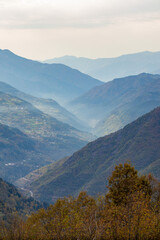 A view of a valley surrounded by mountains on a cloudy day