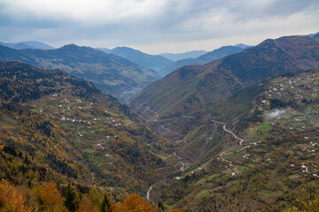 Fototapeta premium A serene valley surrounded by majestic mountains on a cloudy day