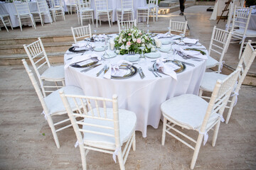 Outdoor Wedding Reception Setup with Elegant Tables and Floral Centerpieces