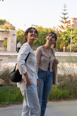 Fototapeta premium Two girls in a loving couple sharing a tender moment at the park