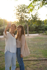Fototapeta premium Two girls taking a selfie at the park.