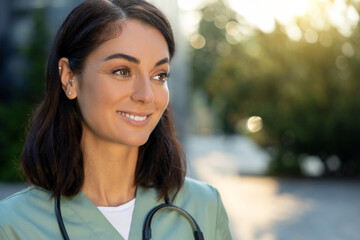 Pretty young female doctor looking thoughtful in the light of morning sun