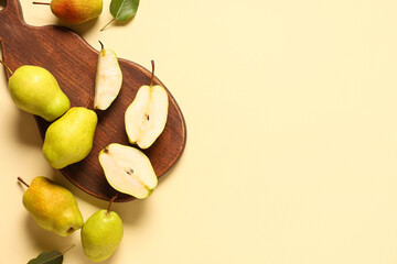 Wooden board with sweet ripe pears on yellow background