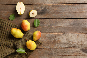 Sweet ripe pears and leaves on wooden background