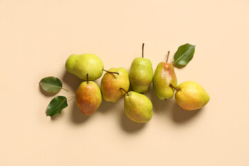 Sweet ripe pears and leaves on beige background