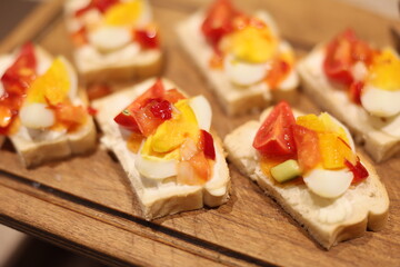 These vibrant and colorful appetizers feature a delightful mix of diced vegetables and eggs atop fresh bread slices