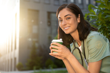 Young female doctor having coffee in the morning after a night shift