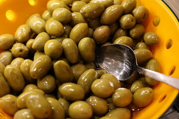 A vibrant and colorful bowl filled with fresh green olives, perfect for snacking or for cooking delicious meals