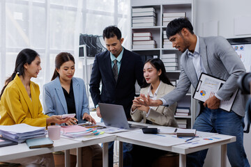 Group of confident business asian people point to graphs and charts to analyze market data, balance sheet, account, net profit to plan new sales strategies to increase production capacity.	