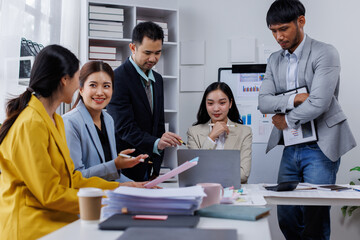 Fototapeta premium Group of confident business asian people point to graphs and charts to analyze market data, balance sheet, account, net profit to plan new sales strategies to increase production capacity. 