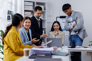 Group of confident business asian people point to graphs and charts to analyze market data, balance sheet, account, net profit to plan new sales strategies to increase production capacity.	