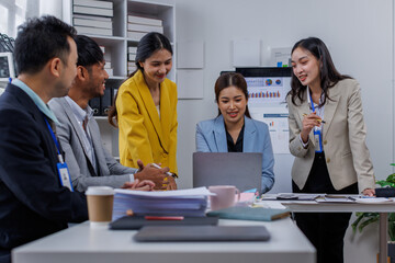 Group of confident business asian people point to graphs and charts to analyze market data, balance sheet, account, net profit to plan new sales strategies to increase production capacity.	