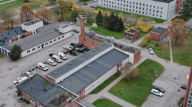 Crematorium building with tall chimney in a hospital area during autumn, aerial view