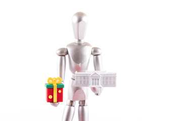 A miniature model of the residence of the US President and a symbolic gift in the hands of the Wooden Man