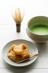 Cup of fresh matcha tea on white wooden table.