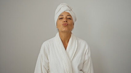 Woman in white bathrobe and towel posing isolated on white background giving a kiss