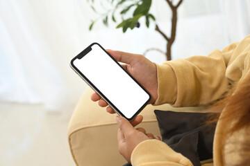 Close up of woman relaxing and holding smartphone with blank display