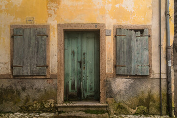 La facciata di una casa abbandonata con la porta e le finestre chiuse nel borgo di Erto, vicino alla diga del Vajont
