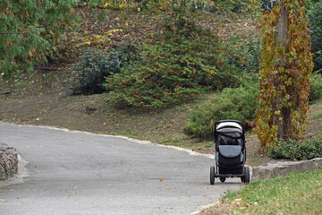 baby stroller in the autumn park. Baby carriage or pushchair. abandoned child, loneliness, orphan....