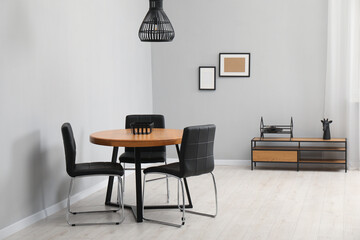 Fototapeta premium Wooden table with black chairs in stylish dining room