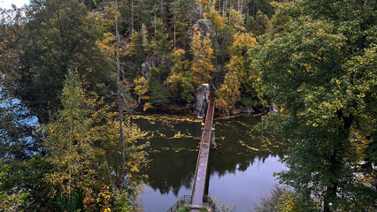Pedestrian bridge across the Bobr River. Autumn landscape with colorful trees on the river bank. View from above. © PRO Balance