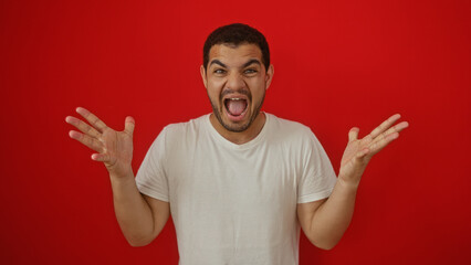 Handsome man expressing excitement over isolated red background, embodying youthful energy and positive emotion.
