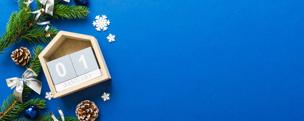 Christmas calendar 1 january. Christmas gift, fir branches, pine cones. Flat lay, top view. New Year decorations on a colored background