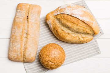 Assortment of freshly baked bread with napkin on rustic table top view. Healthy unleavened bread. French bread