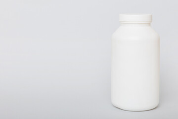 supplement pills with medicine bottle health care and medical top view. Vitamin tablets. Top view mockup bottle for pills and vitamins with green leaves, natural organic bio supplement, copy space