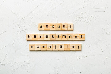 Sexual harassment complaint word written on wood block. Sexual harassment complaint text on table,...