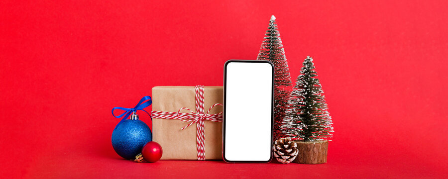Digital phone mock up with rustic Christmas decorations for app presentation with empty space for you design. Christmas online shopping concept. Tablet with copy space on colored background